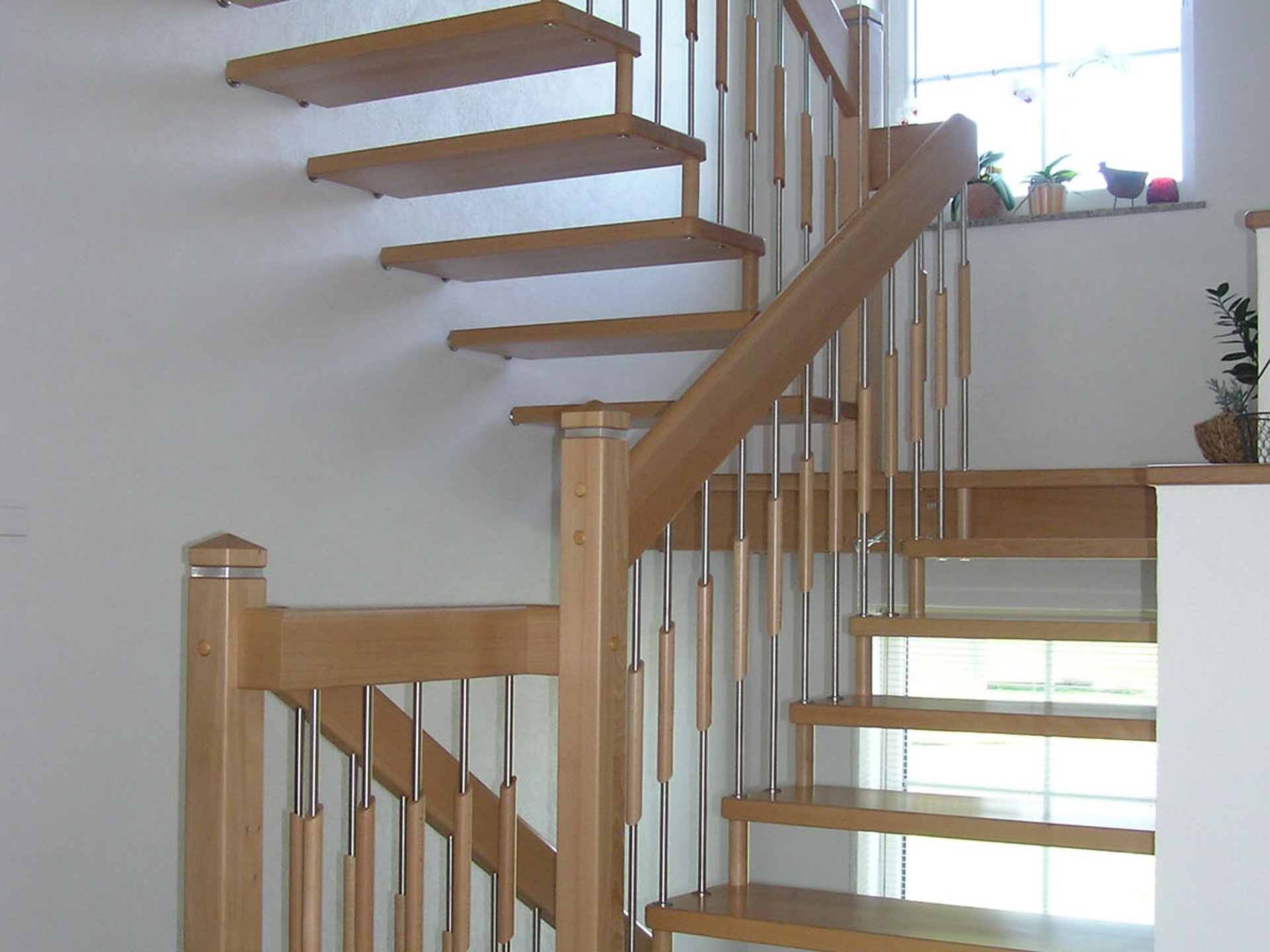 Wandbolzen-Treppe in Buche Natur mit Holzhandlauf und Edelstahlstäben