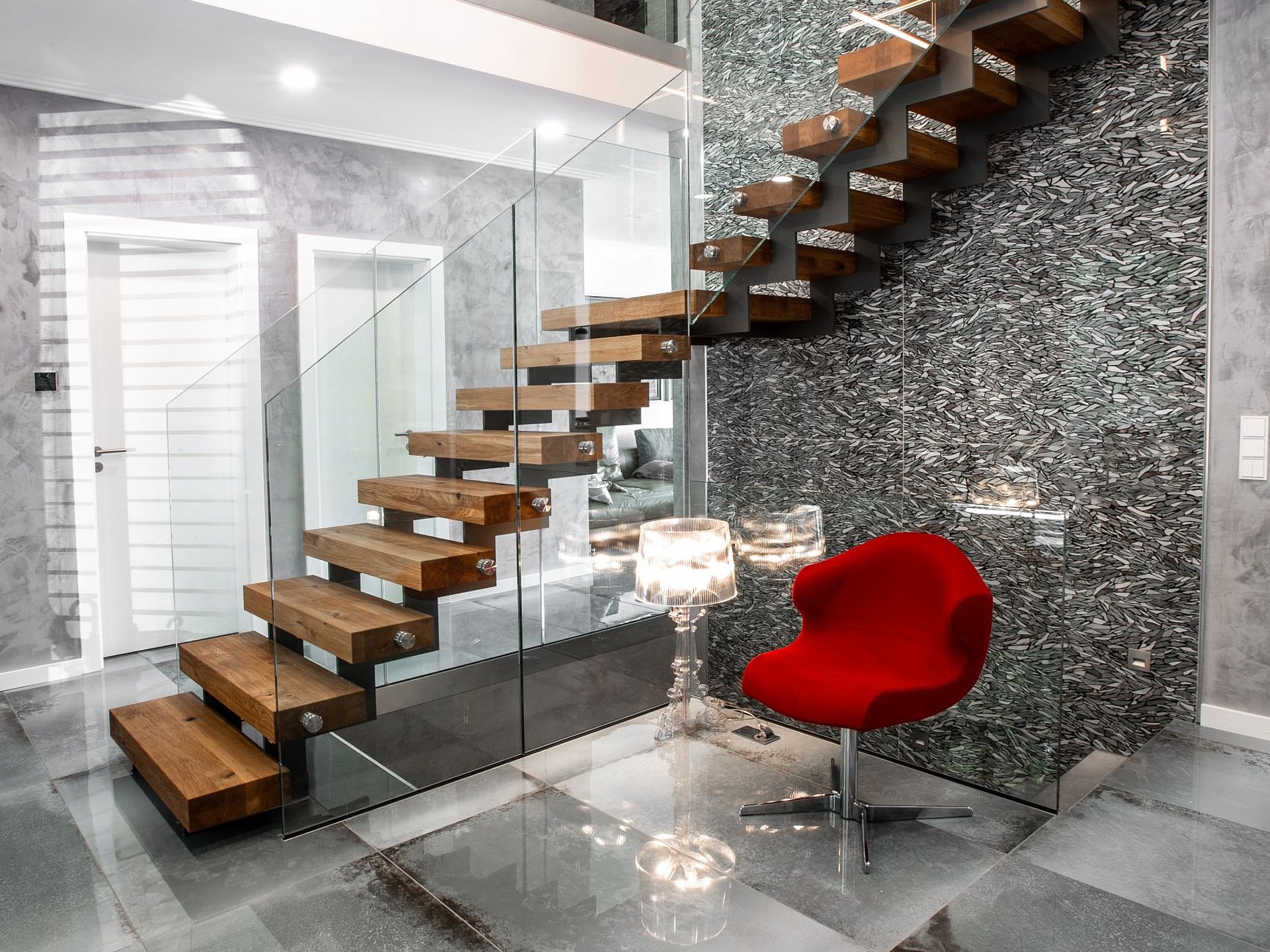 Design-Stahl-Holz-Treppe mit Eichenstufen Blick auf eine Stahl-Holz-Treppe mit massiven Eichenstufen, Zickzackwange und Glasgeländer. Die Kombination aus Stahl, Holz und Glas verbindet modernes Design mit hochwertiger Handwerkskunst.
