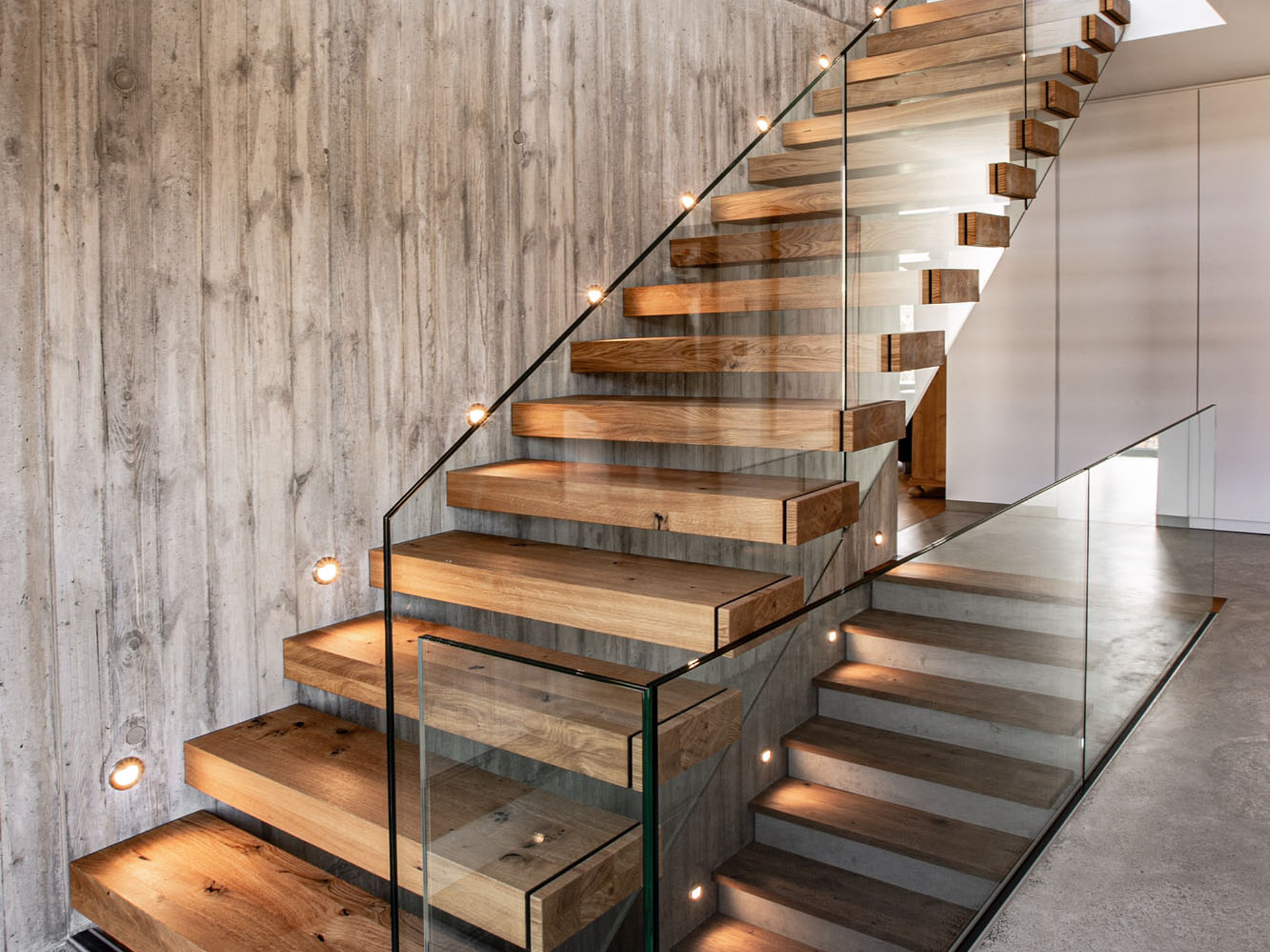 Kragstufentreppe in Wildeiche mit eingespannten Glasgeländer von Krieger-Treppen