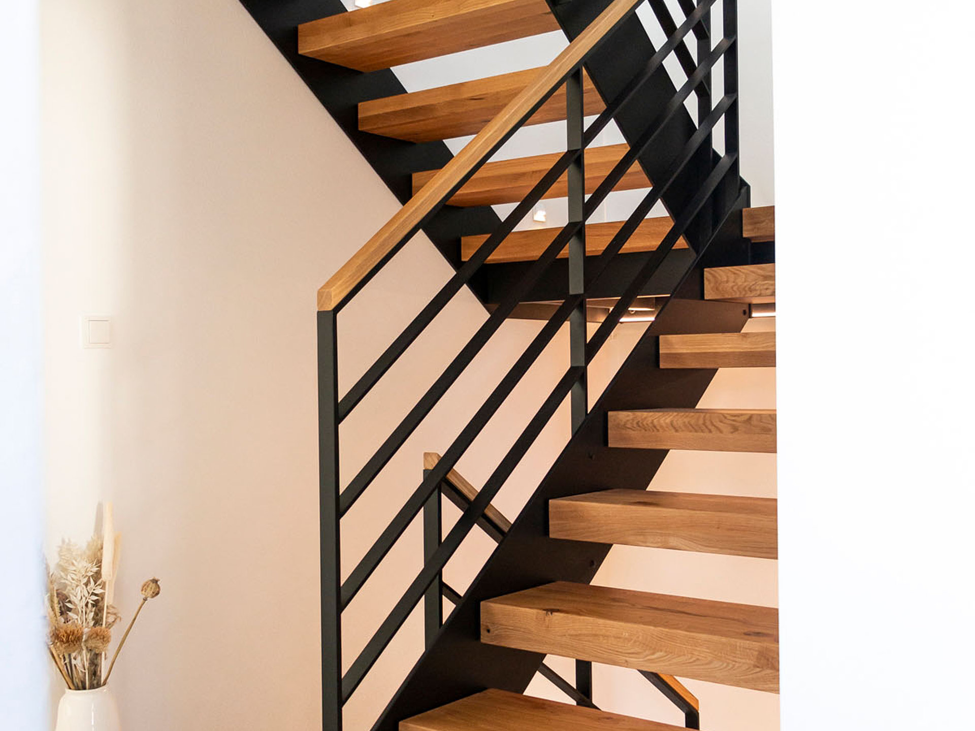 HPL-Treppe mit Flachstahlgeländer und Holzhandlauf in Eiche