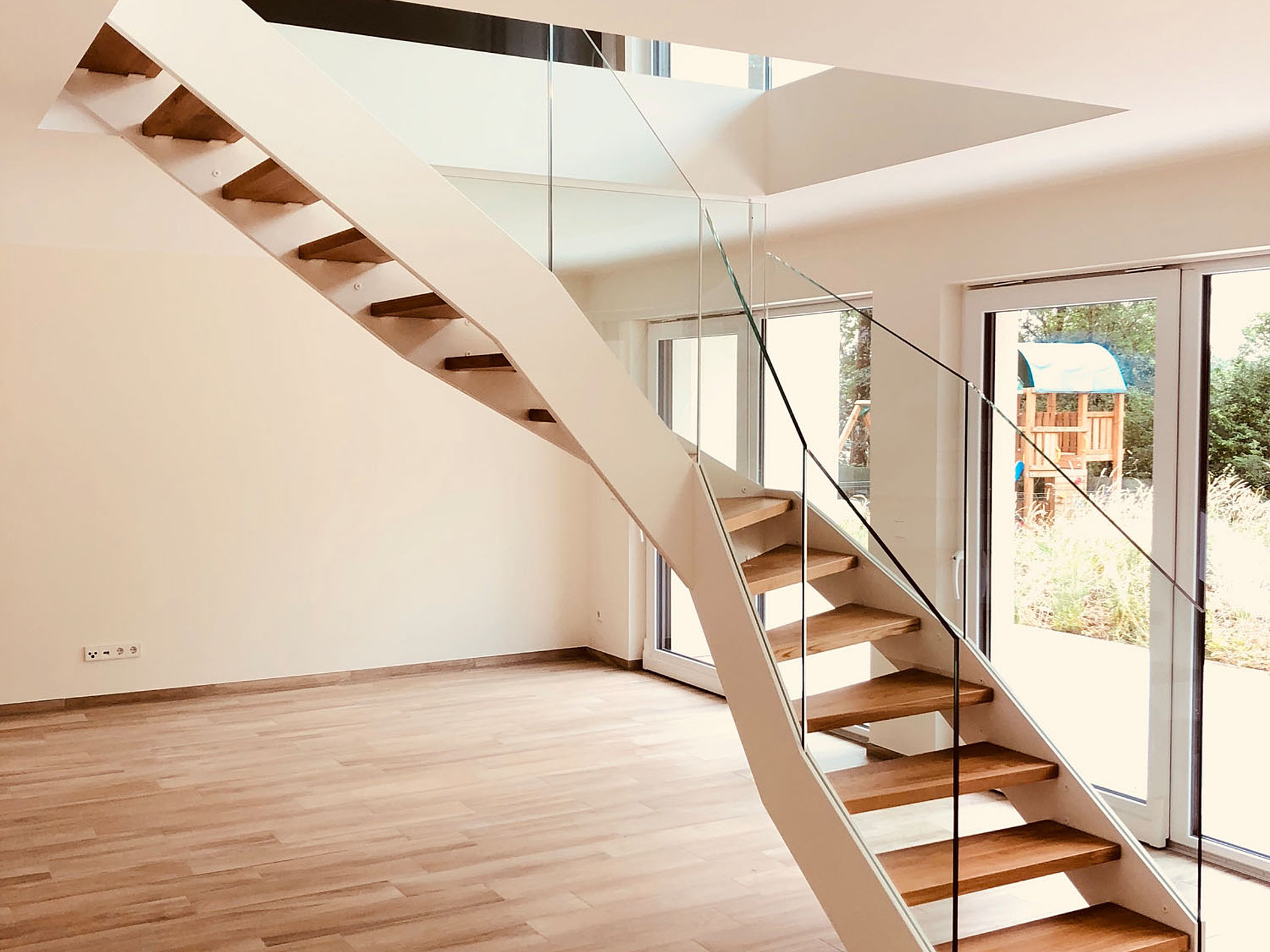 Weiße HPL-Treppe mit eingespanntem Glasgeländer