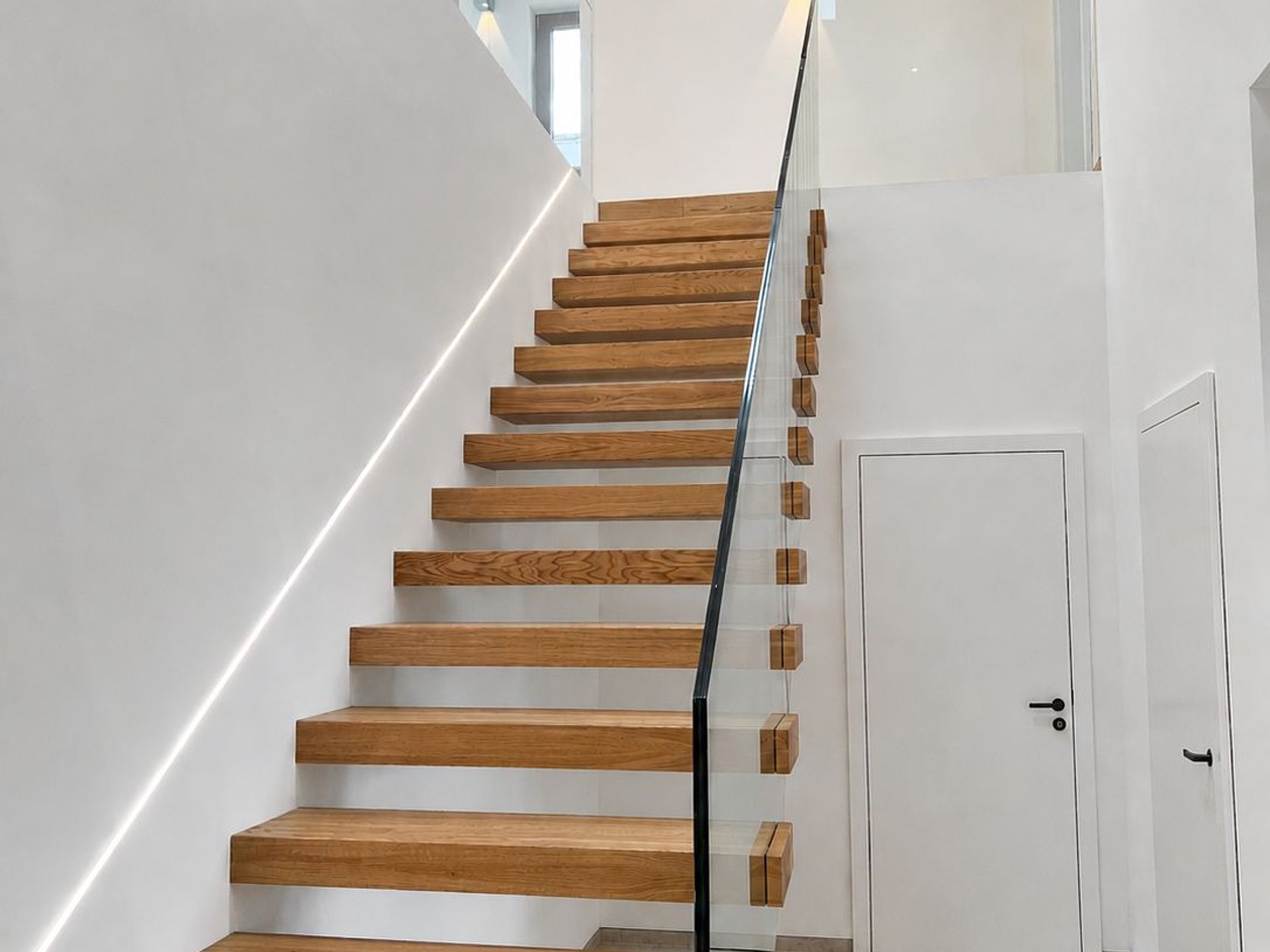 Kragarmtreppe mit Eichenstufen und Glasgeländer Kragarmtreppe mit Eichenstufen und Glasgeländer
