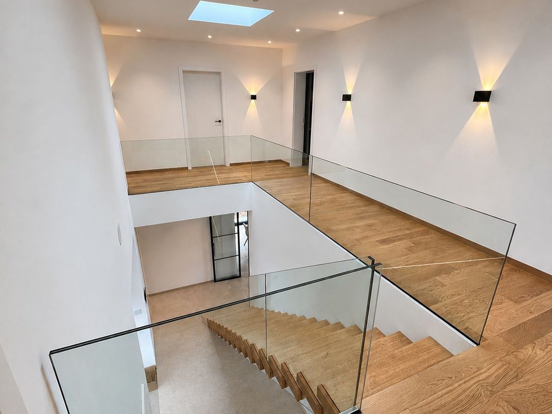 Ganzglasgeländer mit Blick auf die schwebend wirkenden Kragstufen Ganzglasgeländer mit Blick auf die schwebend wirkenden Kragstufen