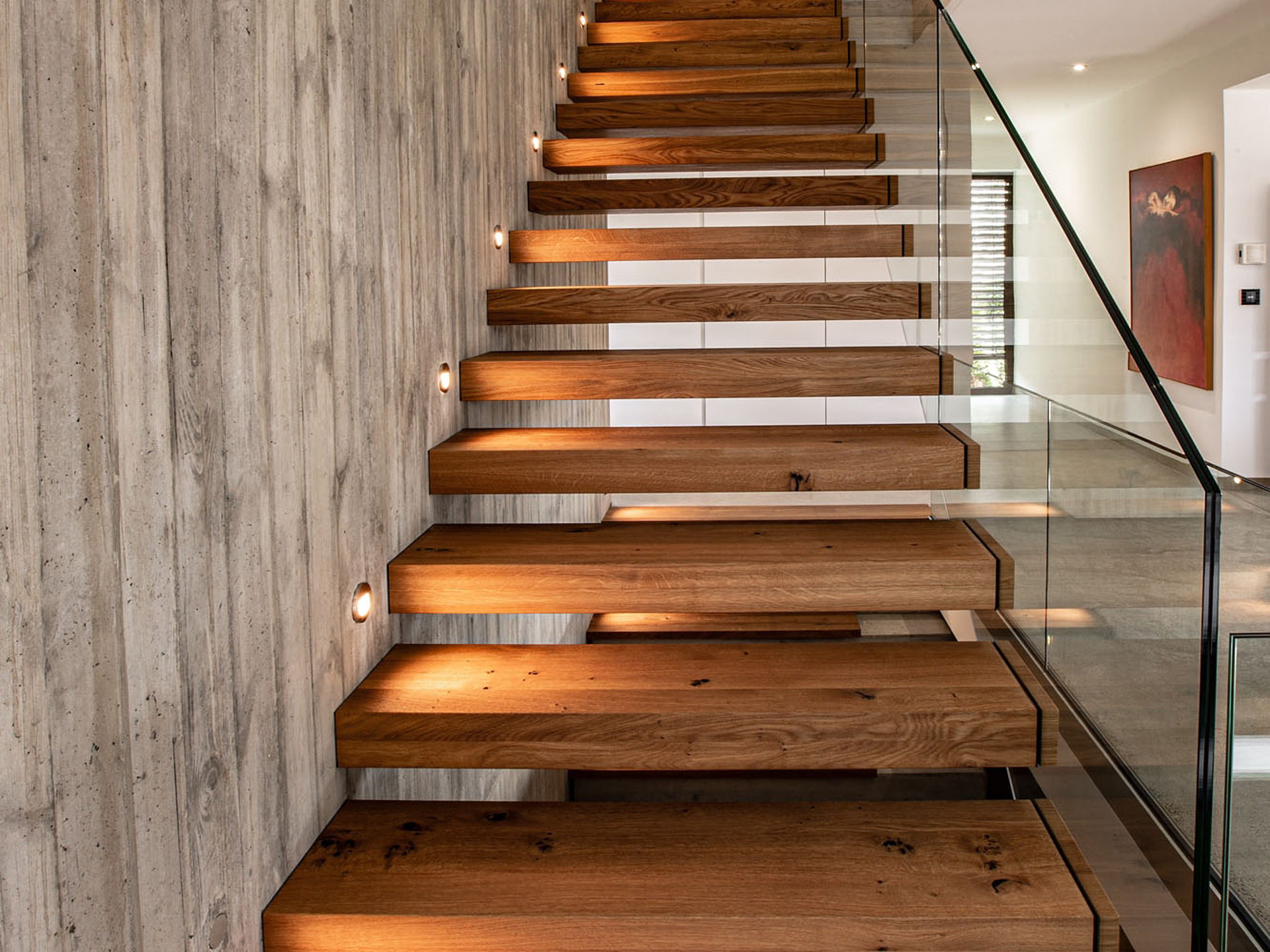 Beleuchtete Kragstufentreppe mit Ganzglasgeländer von Krieger-Treppen